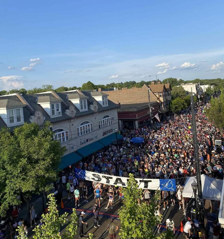 Aerial view of thousands of runners packed down State Street behind the Media 5 Mile start banner